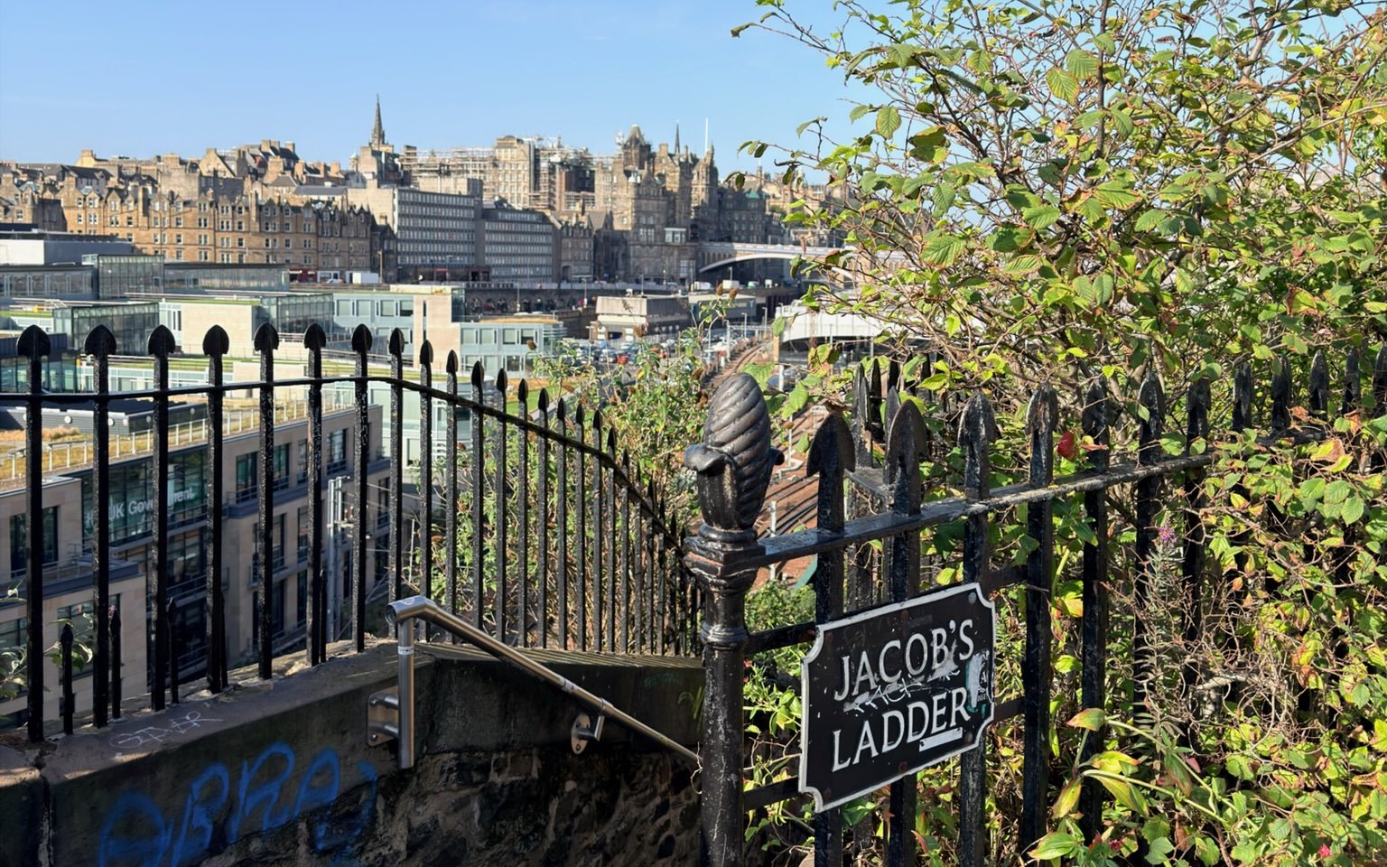Edinburgh's Old Town seen over the railings at the top of Jacob's Ladder, beside its street sign.
